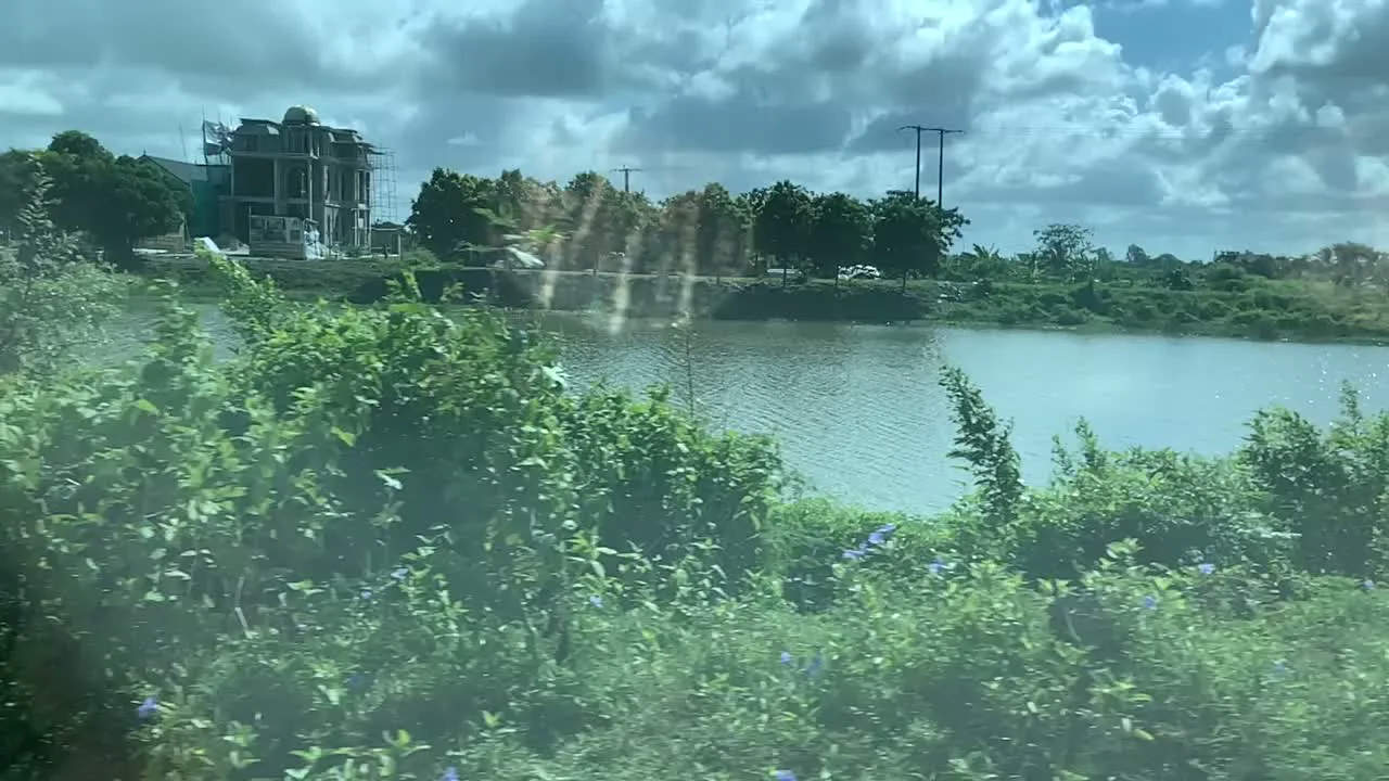 Video ghi lại khung cảnh vùng nông thôn ở khu vực Nga Sơn, được quay từ một phương tiện đang di chuyển. Cảnh vật chủ yếu là một cái ao (hoặc hồ) lớn, mặt nước gợn sóng. Xung quanh ao là cây cối và các bụi cây rậm rạp. Ở phía xa, bên kia bờ ao, có một ngôi nhà lớn nhiều tầng đang được xây dựng, kiến trúc giống một biệt thự. Ngoài ra còn có thể nhìn thấy một vài ngôi nhà dân khác và các cột điện cao thế. Bầu trời nhiều mây nhưng vẫn có ánh nắng. Không có hoạt động cụ thể của con người được quan sát rõ ràng, ngoại trừ việc có một công trình xây dựng đang diễn ra.