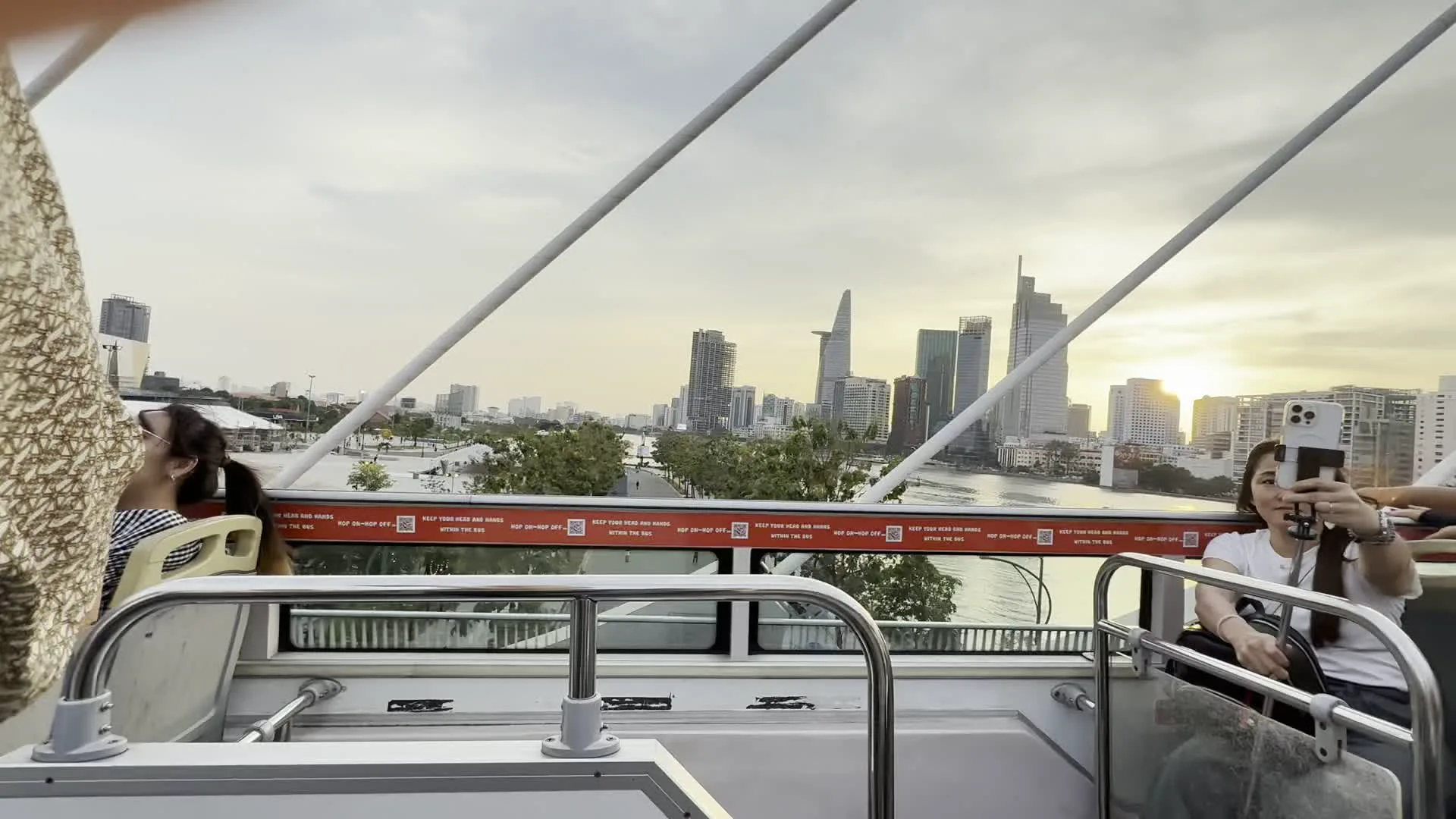 Tòa nhà Bitexco Financial Tower (ビテクスコ・フィナンシャルタワー)。Landmark 81 (ランドマーク81)。Hop On - Hop Off (乗り降り自由の観光バスの注意書き)。KEEP YOUR HEAD AND HANDS WITHIN THE BUS (頭や手をバスの中から出さないでください、という注意書き)