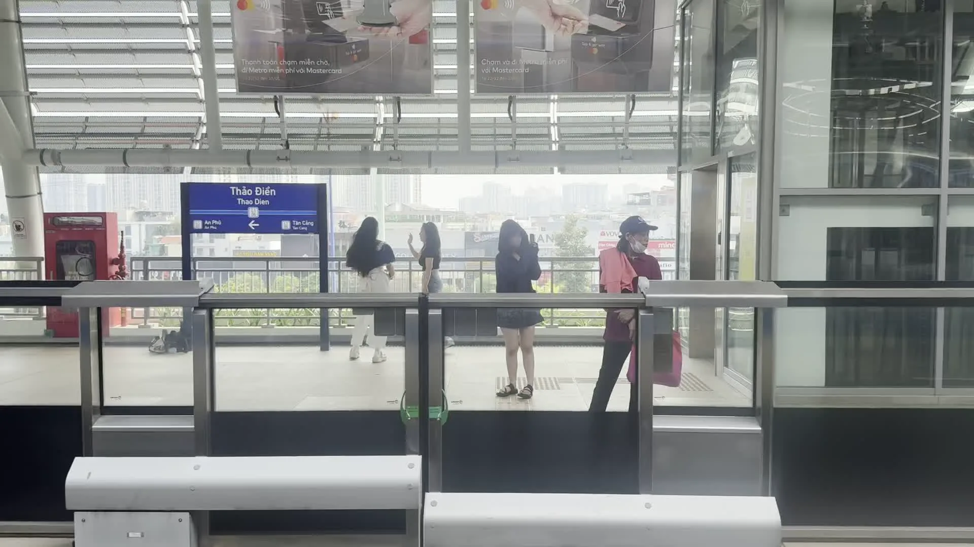 Ga Thảo Điền (An Phú ← Thảo Điền → Tân Cảng)（タオディエン駅（ホーチミン市メトロ1号線の駅名標。行き先はアンフー駅方面とタンカン駅方面）。Chạm và đi với Mastercard（Mastercardでタッチ＆ゴー（ホーチミン市メトロ駅構内の広告）。SONKIM LAND（ソンキムランド（ベトナムの不動産開発会社の広告看板）