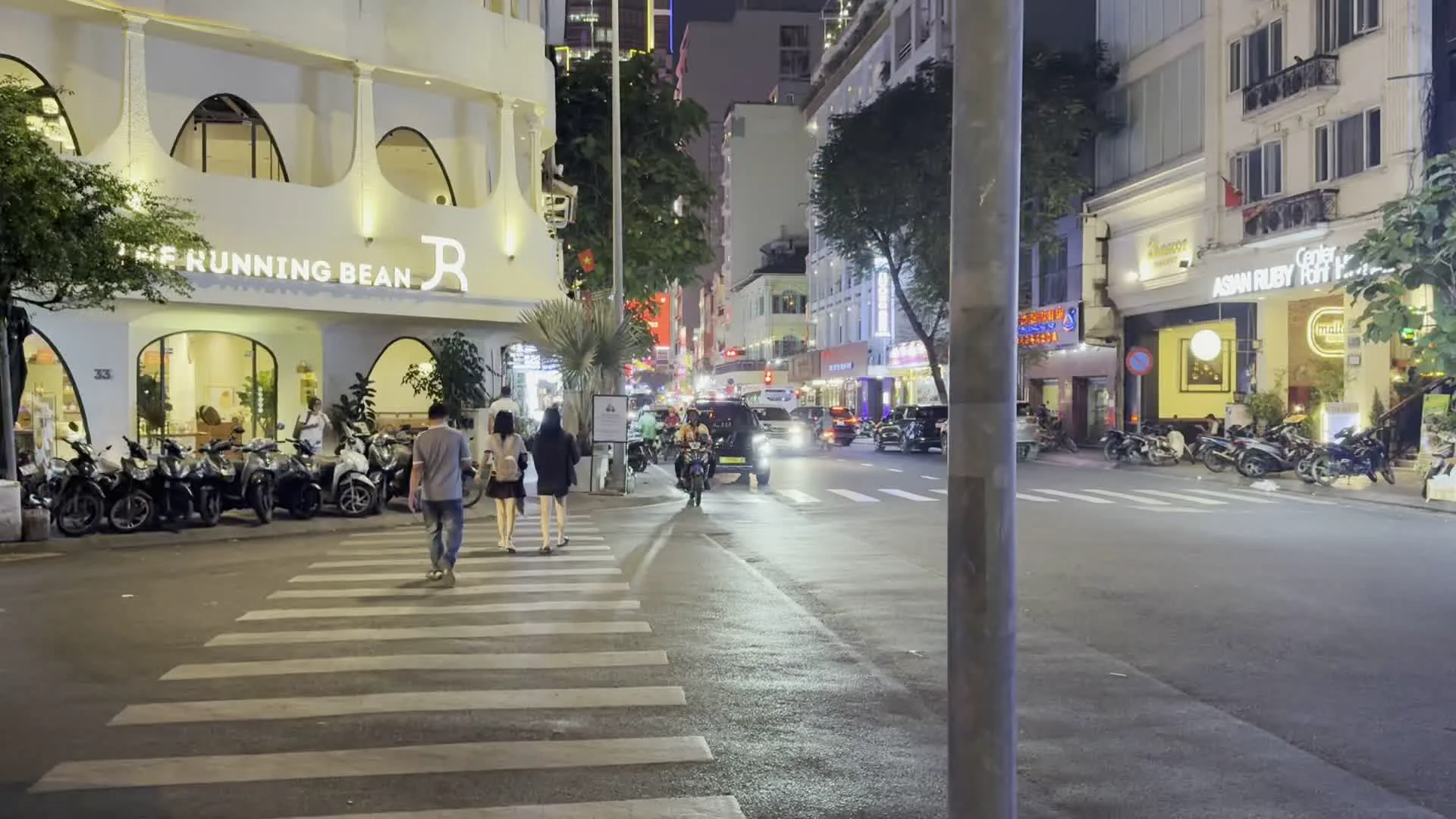 Đường Mạc Thị Bưởi (マク・ティ・ブオイ通り)。The Running Bean (カフェの看板)。Asian Ruby Hotel (ホテルの看板)。Stoker (レストランの看板)。7-Eleven (コンビニエンスストアの看板)。Maigu Drinker / TRÀ SỮA & VIỆT (ドリンクショップの看板 / ミルクティー＆ベトナム)