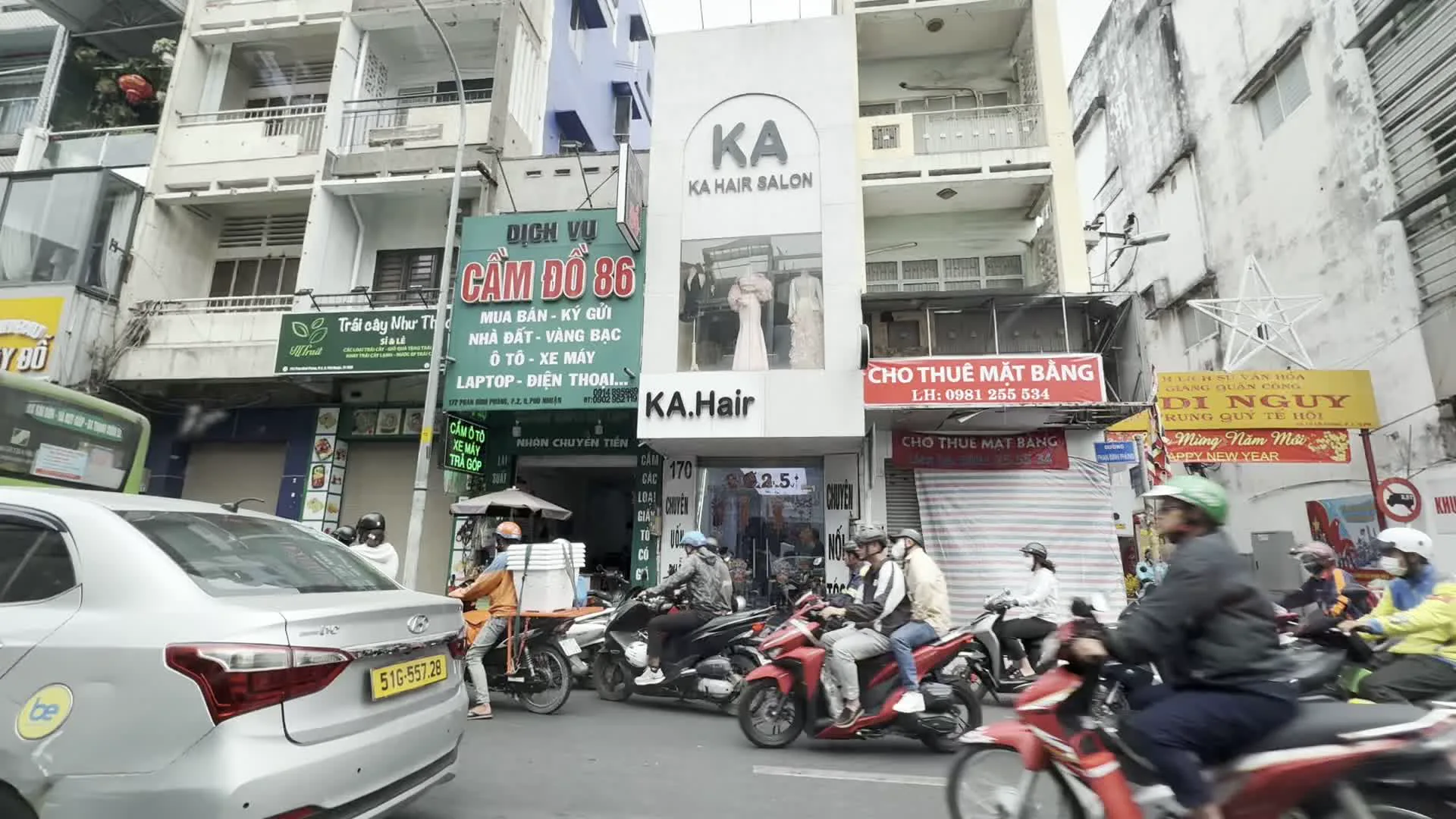 DỊCH VỤ CẦM ĐỒ 86 (質屋86サービス)。CHO THUÊ MẶT BẰNG (店舗・敷地貸し)。Mừng Năm Mới / HAPPY NEW YEAR (新年おめでとう)。VĂN PHÒNG CÔNG CHỨNG VÕ THỊ VÂN ANH (ヴォー・ティ・ヴァン・アイン公証人事務所)。BAN CHỈ HUY QUÂN SỰ PHƯỜNG 7 (第7坊軍事指揮部)。KLEVER FRUIT (クレバー・フルーツ - 果物店)。PHÚ VINH (フー・ヴィン - 宝飾店)。KA HAIR SALON (KAヘアーサロン)