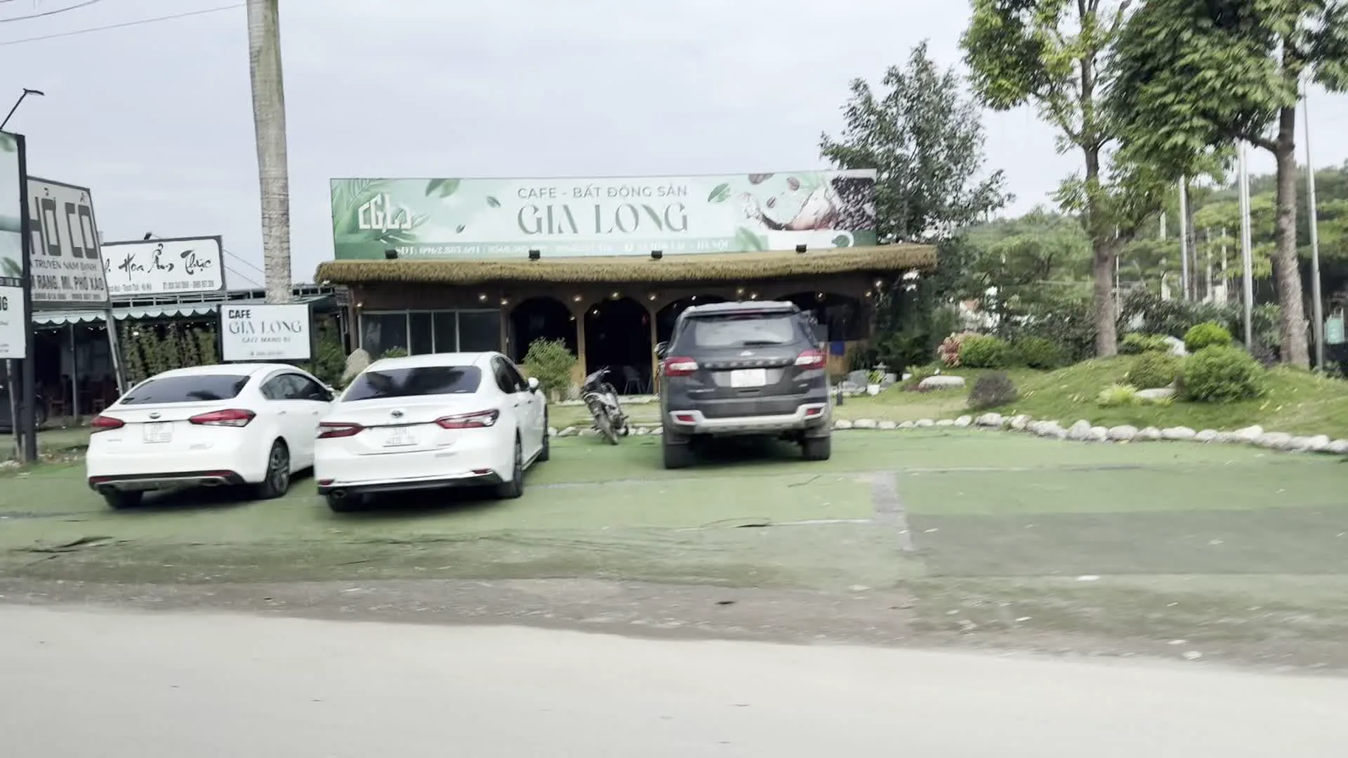 CAFE - BẤT ĐỘNG SẢN GIA LONG（ザロン・カフェ＆不動産）。Dốc Cun, TP. Hòa Bình, T. Hòa Bình（ゾックン坂、ホアビン市、ホアビン省の地名表示）。BÚN CHẢ PHỞ BÒ GIA TRUYỀN（家伝のブンチャーと牛肉フォーの食堂）。PHỞ BÒ GIA TRUYỀN NAM ĐỊNH（ナムディン家伝の牛肉フォーの看板）。CÔNG TY CỔ PHẦN 559 BA VÌ - TRẠM DỪNG NGHỈ 192（559バヴィ株式会社 - 192休憩所）。SỮA BÒ, DÊ（牛乳、ヤギ乳の看板）。CÓ BÃI XE（駐車場ありの看板）