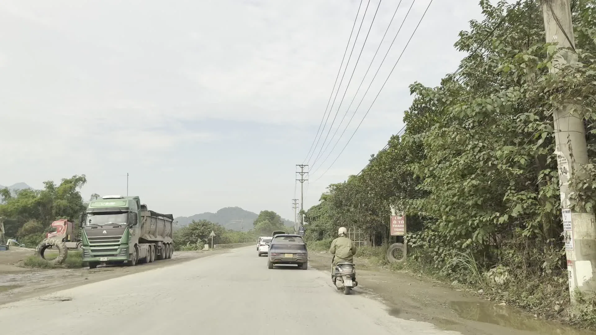 Tp. HÒA BÌNH 500m（Thành phố Hòa Bình 500m - ホアビン市まで500mの道路標識）。Ống thép Hòa Phát（ホアファット鋼管の看板）。VLXD（Vật liệu xây dựng - 建築資材店の看板）