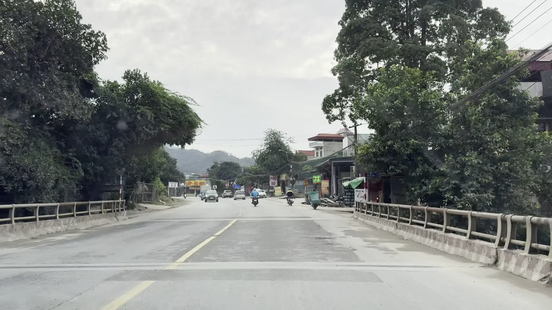 VUA LỐP（タイヤの王様 - タイヤ店の看板）。VUA ẮC QUY（バッテリーの王様 - バッテリー店の看板）。Cầu Hòa Bình 2（ホアビン第2橋）。Sông Đà（ダー川）