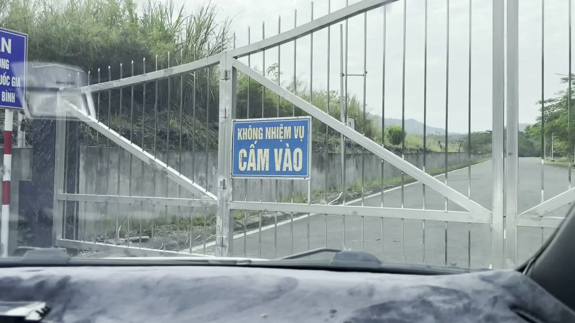 KHÔNG NHIỆM VỤ CẤM VÀO（用務外の者、立ち入り禁止の看板）。... QUAN TRỌNG, AN NINH QUỐC GIA, ...ĐIỆN HÒA BÌNH（「...重要、国家安全保障、...ホアビン電力」と記された看板。フォルダ名とGPS座標から、ホアビン省内の電力関連の重要施設への入口であることを示す）