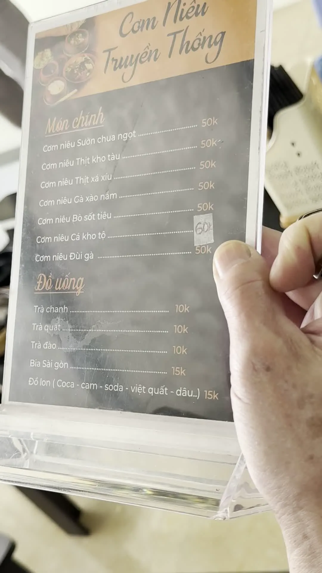 Cơm Niêu Truyền Thống（伝統的な土鍋ご飯レストランのメニュー）。Món chính（メインディッシュ）。Cơm niêu Sườn chua ngọt（土鍋ご飯と甘酢スペアリブ）。Cơm niêu Thịt kho tàu（土鍋ご飯と豚の角煮）。Cơm niêu Thịt xá xíu（土鍋ご飯とチャーシュー）。Cơm niêu Gà xào nấm（土鍋ご飯と鶏肉とキノコの炒め物）。Cơm niêu Bò sốt tiêu（土鍋ご飯と牛肉のペッパーソース煮込み）。Cơm niêu Cá kho tộ（土鍋ご飯と魚の土鍋煮込み）。Cơm niêu Đùi gà（土鍋ご飯と鶏もも肉）。Đồ uống（飲み物）。Trà chanh（レモンティー）。Trà quất（キンカンティー）。Trà đào（ピーチティー）。Bia Sài gòn（サイゴンビール）。Đồ lon (Coca - cam - soda - việt quất - dâu..)（缶飲料：コーラ、オレンジ、ソーダ、ブルーベリー、イチゴなど）