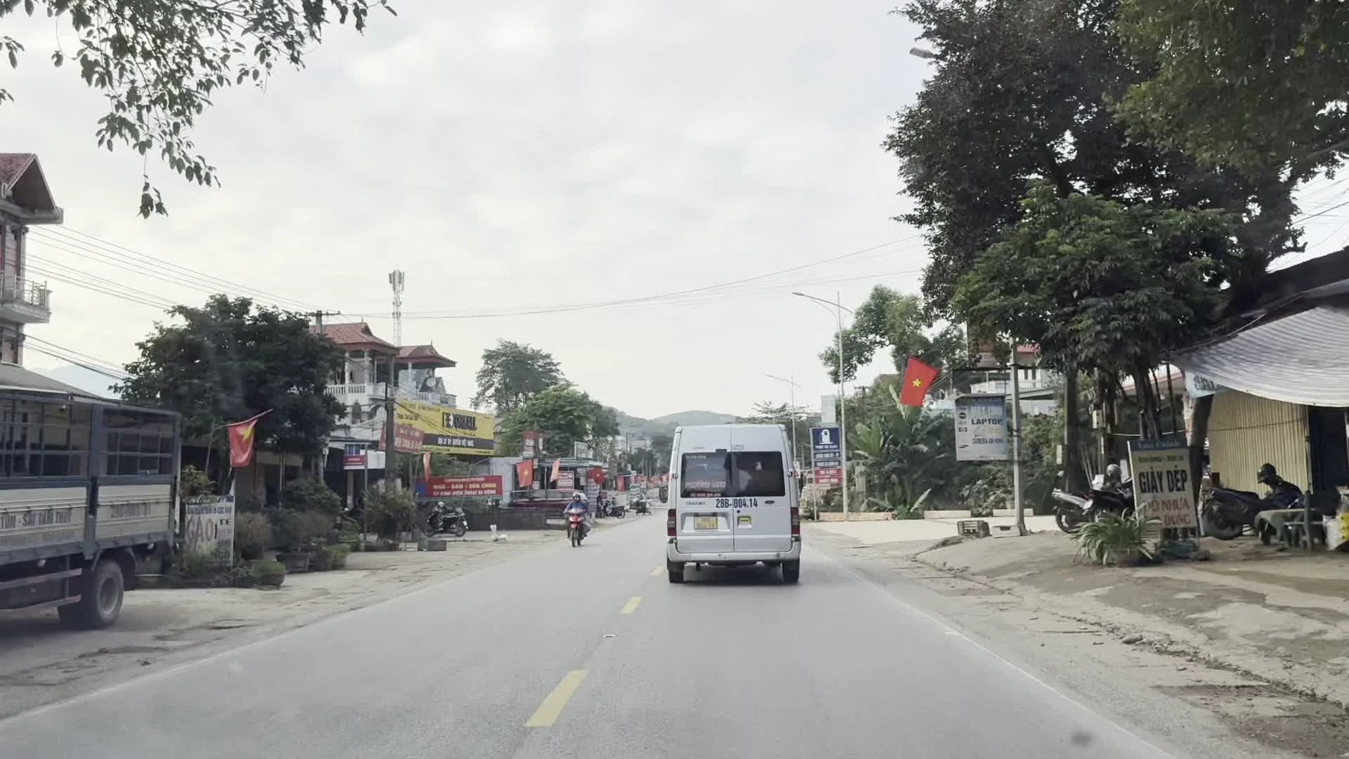 Biển số xe 28B-004.14（ホアビン省の車両ナンバープレート。先頭の「28」はホアビン省を示す地域コード）。TÓC - NAIL（ヘアサロン・ネイルサロン）。QUAY THUOC（薬局）