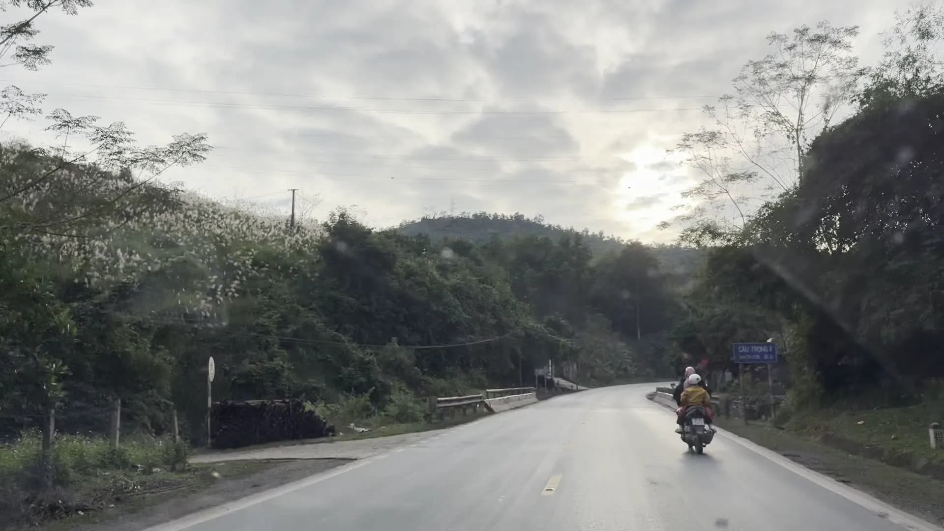 CẦU TRUÔNG V, Km 23+750（チュオンV橋、国道23.750km地点を示す標識）。TRẠM DỪNG NGHỈ VỊT CỔ LŨNG - GÀ ĐỒI（休憩所の看板。「コルン・アヒル」と「丘の鶏」という名物料理、レストラン、特産品販売、ホームステイを宣伝）