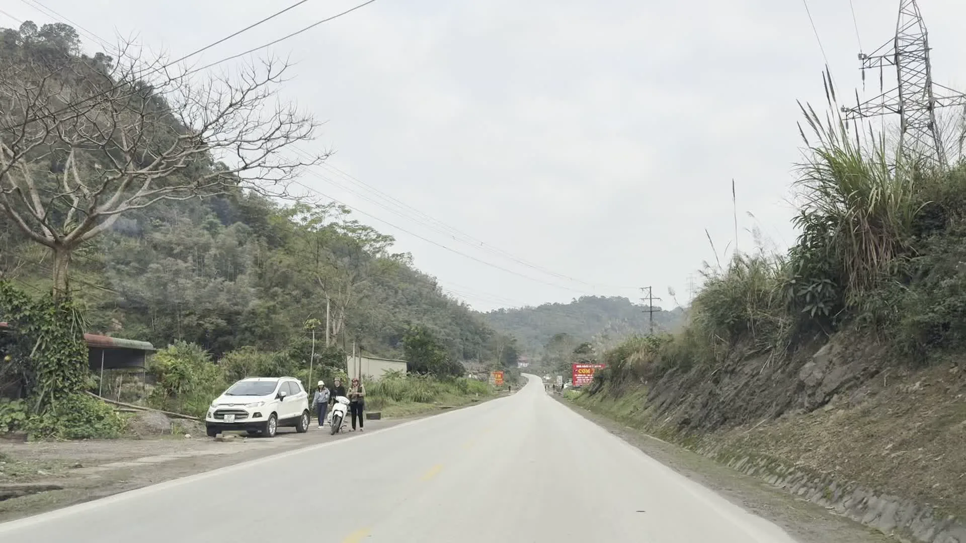 NHÀ HÀNG QUYẾT HÙNG（クイェット・フン食堂）。CƠM XE（長距離ドライバー向けの食堂を示す看板）。ĐẶC SẢN LỢN BẢN - GÀ ĐỒI（地元の豚・丘の鶏の特産料理を示す看板）。TRÂU LÁ LỐM - LẨU CÁC LOẠI（ラーロムの葉で包んだ水牛料理・各種鍋料理を示す看板）。CÁ SÔNG ĐÀ（ダ川の魚。GPS座標が示すホアビン省を流れるダ川との関連性を示唆する看板）。CƠM PHỞ BÚN CHẢ（ご飯・フォー・ブンチャー。ベトナムの一般的な食事メニューを示す看板）