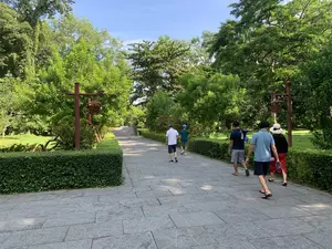 ラムキン遺跡の緑豊かな木々に囲まれた石畳の参道。数人の観光客が奥に向かって歩いている