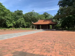 赤いレンガ敷きの広い広場の先に、伝統的な様式の木造建築物がある。オレンジ色の瓦屋根を持ち、周囲は豊かな緑に囲まれている