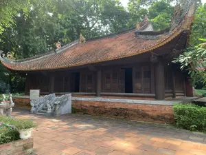 TẢ VU - HỮU VU。Tả vu và Hữu vu là hai dãy nhà đối xứng nhau qua sân Rồng, nằm ở hai bên tả, hữu của chính điện.。Hai dãy nhà này được dựng trên nền cao 0,9m, bó vỉa bằng gạch vồ, nền lát gạch Bát Tràng.。Mỗi dãy gồm 7 gian, 2 chái, vì kèo theo kiểu chồng rường giá chiêng. Mái lợp ngói mũi hài. Tả vu và Hữu vu là nơi dành cho các văn quan, võ quan chuẩn bị phẩm phục, nghi lễ trước khi vào triều yết.。Năm 1999, hai dãy nhà được phục dựng lại trên nền móng cũ.。（日本語訳）。左廡・右廡。左廡と右廡は、龍の庭を挟んで対称に配置された2棟の建物で、正殿の左右に位置しています。この2棟は高さ0.9mの基礎の上に建てられ、縁石は粗煉瓦で組まれ、床にはバッチャン煉瓦が敷かれています。各棟は7つの間と2つの翼廊からなり、小屋組は鐘形の枠を重ねる様式です。屋根はムイハイ瓦（靴のつま先のような形の瓦）で葺かれています。左廡と右廡は、文官や武官が朝廷に参内する前に、祭服や儀礼の準備をするための場所でした。1999年、この2棟は古い基礎の上に復元されました