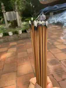 燃えさしから煙が立ち上る線香の束