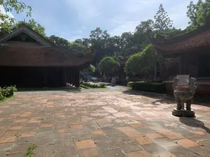 レンガ敷きの広場を挟んで、ベトナムの伝統的な木造建築が左右対称に配置されている