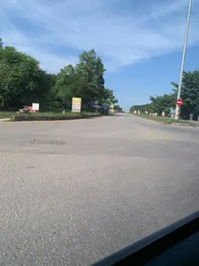 道路の分岐点から撮影された風景。左手奥に看板が数枚立っているが、距離と解像度の問題で書かれている文字は右手前には円形の進入禁止標識