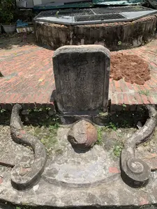 Bức ảnh chụp một không gian ngoài trời tại một di tích cổ, có một cái giếng cổ và một tấm bia đá. Tấm bia đá cũ được đặt ở vị trí trung tâm, phía trước giếng. Trên bia có khắc chữ Hán theo ba hàng dọc:。- Hàng bên phải: 龍飛癸酉年造 (Long phi Quý Dậu niên tạo), nghĩa là được làm vào năm Quý Dậu, niên hiệu Long Phi.。- Hàng giữa: 一片氷心 (Nhất phiến băng tâm), một thành ngữ có nghĩa là một tấm lòng trong sáng, thanh khiết.。- Hàng bên trái: 局口職員 (Cục khẩu chức viên), có thể chỉ các viên chức tại một địa điểm hoặc cơ quan tên là Cục Khẩu.。Phía sau tấm bia là một cái giếng cổ hình tròn, thành giếng được xây bằng gạch và xi măng đã cũ kỹ. Miệng giếng được đậy bằng một tấm lưới kim loại. Nền sân được lát bằng gạch đỏ. Phía trước bia đá có một cấu trúc bằng đá giống như máng nước với các chi tiết trang trí uốn cong. Cỏ dại mọc xen kẽ trên nền gạch và xung quanh các công trình.。（日本語訳）。古代遺跡の屋外空間を写した写真で、古い井戸と石碑があります。古い石碑は中央、井戸の前に置かれています。碑には漢文が縦三行で刻まれています。- 右の行：龍飛癸酉年造（Long phi Quý Dậu niên tạo）、意味は龍飛年間の癸酉の年に作られた。- 中央の行：一片氷心（Nhất phiến băng tâm）、清らかで純粋な心を意味する成句です。- 左の行：局口職員（Cục khẩu chức viên）、Cục Khẩuという場所または機関の役人を示す可能性があります。石碑の後ろには古い円形の井戸があり、井戸の縁は古いレンガとセメントで造られています。井戸の口は金属製の網で覆われています。庭の地面は赤レンガで敷き詰められています。石碑の前には、湾曲した装飾が施された水槽のような石造りの構造物があります。雑草がレンガの床や建造物の周りに点在して生えています。