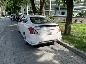 Chữ viết trên biển hiệu của tòa nhà: "TRUNG TÂM PHỤC VỤ HÀNH CHÍNH CÔNG TỈNH. ĐỊA CHỈ: 29 ĐẠI LỘ LÊ LỢI, PHƯỜNG ĐIỆN BIÊN, TP. THANH HÓA". Chữ viết trên xe ô tô là "SUNNY" và "XT Premium".。Bối cảnh là một con đường đô thị với vỉa hè được lát gạch. Một chiếc ô tô sedan màu trắng, hiệu Nissan Sunny, đang đỗ trên vỉa hè. Dọc theo con đường có nhiều cây xanh, bao gồm cả cây cọ, tạo bóng mát. Phía sau hàng cây là một tòa nhà văn phòng cao tầng, hiện đại, được xác định là Trung tâm Phục vụ Hành chính công tỉnh Thanh Hóa. Ở phía xa trên đường, có thể thấy một vài người và các phương tiện khác như xe máy và ô tô đang đỗ.。（日本語訳）。建物の看板の文字：「省公共行政サービスセンター。住所：タインホア市ディエンビエン坊レロイ大通り29番地」。車に書かれている文字は「SUNNY」と「XT Premium」です。背景は、タイルで舗装された歩道のある都市の道路です。日産サニーの白いセダン車が歩道に駐車しています。道路沿いには、ヤシの木を含む多くの緑の木があり、木陰を作っています。並木の後ろには、タインホア省公共行政サービスセンターと特定される近代的な高層オフィスビルがあります。道路の遠くには、数人の人々と、バイクや駐車している車などの他の乗り物が見えます。