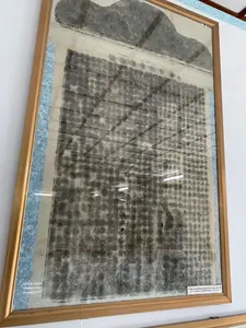 Trong ảnh là một thác bản bia đá cổ được lồng trong một khung gỗ màu vàng nâu và treo trên tường trắng. Thác bản này được làm trên giấy, thể hiện các ký tự chữ Hán hoặc chữ Nôm màu đen, được sắp xếp thành các cột. Do thời gian, nhiều ký tự đã bị mờ và khó đọc. Ở góc dưới bên phải của khung có một nhãn chú thích bằng chữ Quốc ngữ với nội dung: "Trùng tu Bình Khương miếu bia chí dựng năm 1920 (Ghi việc trùng tu miếu Bình Khương và việc lập bia)". Đây là một hiện vật lịch sử đang được trưng bày, có thể ở trong một ngôi miếu, nhà thờ hoặc khu di tích.。（日本語訳）。写真には、黄褐色の木製フレームに入れられ、白い壁に掛けられている古い石碑の拓本が写っている。この拓本は紙に作られており、黒い漢字またはチュノムの文字が縦書きに並べられている。時間の経過により、多くの文字が掠れて読みにくくなっている。フレームの右下隅には、クオックグー（ベトナム語アルファベット）による注釈ラベルがあり、その内容は「1920年に建立された平姜廟碑誌の修復（平姜廟の修復と碑の建立を記録）」となっている。これは展示されている歴史的な展示物であり、廟、祠堂、または遺跡地区にある可能性がある。