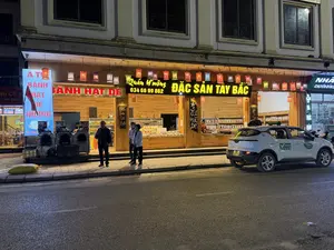 A TỦ BÁNH HẠT DẺ NƯỚNG. BÁNH HẠT DẺ. Quán H'mông 034 66 99 862. ĐẶC SẢN TÂY BẮC. Thịt Trâu Gác Bếp. NG CÔ N. GÀ BẢN. GÀ ĐEN LỢN BẢN. NHÀ THUỐC HOÀNG. CHUYÊN BÁN LẺ. ĐC: Kiot 2 Đ.N1-Sa Pa - Lào Cai. XANH SM 02143 81 81 81. TAXI Green. 24E 002.72.。（日本語訳）。焼き栗菓子の棚。栗菓子。モン族の店 034 66 99 862。西北地方の特産品。水牛の干し肉。美味しい。地鶏。烏骨鶏、地元の豚。ホアン薬局。小売専門。住所：キオスク2、N1通り、サパ、ラオカイ。XANH SM 02143 81 81 81。グリーンタクシー。24E 002.72。