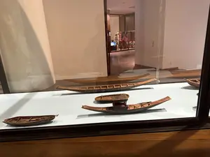 ガラスケースの中に、様々な大きさの木製の船の模型が複数展示されている