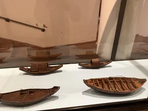 博物館のガラスケース内に展示された、複数の木製の船の模型
