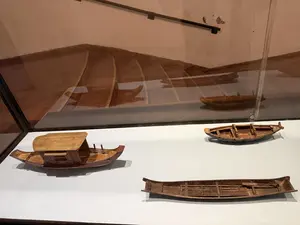 ガラスケースの中に展示された、複数の木製ボートの模型。画像内に書き起こしの対象となる文字はありません