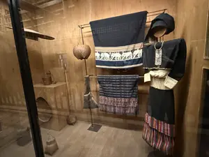 博物館の展示風景。土壁の部屋に、民族衣装を着たマネキン、象の模様の織物、カゴ、生活道具などが展示されている
