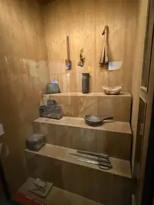 階段状の展示台に、農具や調理器具と思われるフライパン、ナイフ、ハサミなどが陳列されている