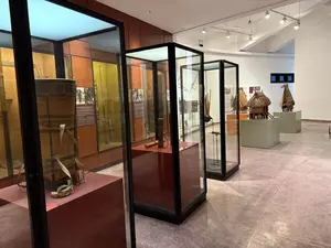 [博物館の展示室内。ガラスケースの中に民族衣装や道具などが展示されている