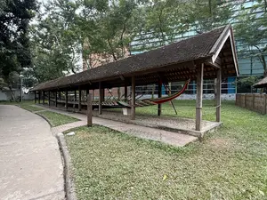 画像に文字はありません。長い木製の屋根の下に、細長い船が置かれています